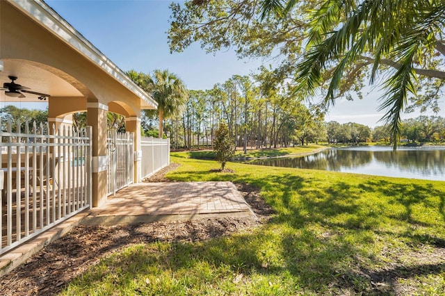 view of yard with ceiling fan, a water view, and a patio