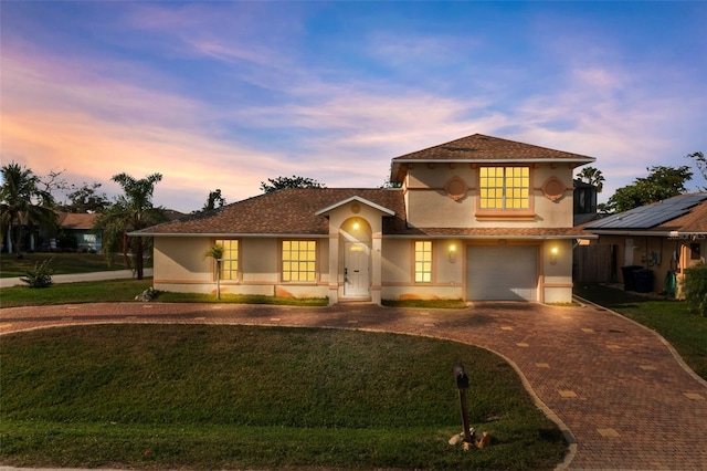 mediterranean / spanish house featuring a lawn and a garage