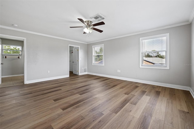 spare room with hardwood / wood-style floors, crown molding, and a healthy amount of sunlight