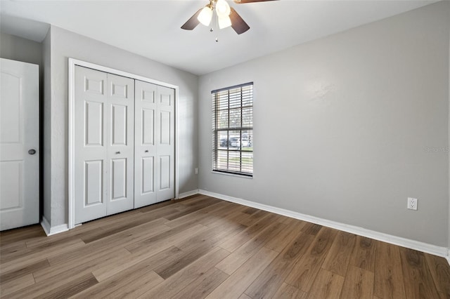 unfurnished bedroom with ceiling fan, a closet, and light hardwood / wood-style floors