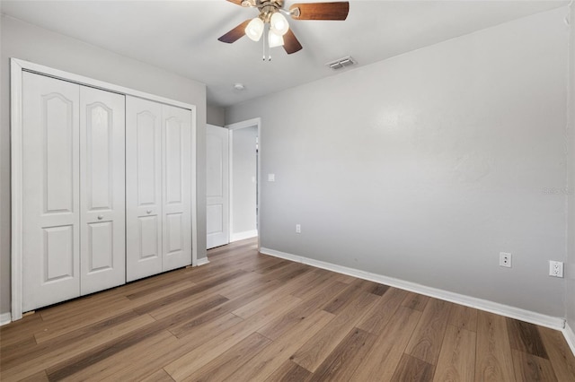 unfurnished bedroom with ceiling fan, light hardwood / wood-style flooring, and a closet