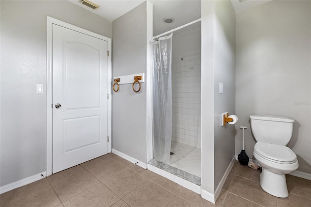 bathroom featuring tile patterned floors, toilet, and a shower with shower curtain