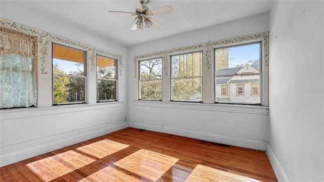 unfurnished sunroom featuring ceiling fan