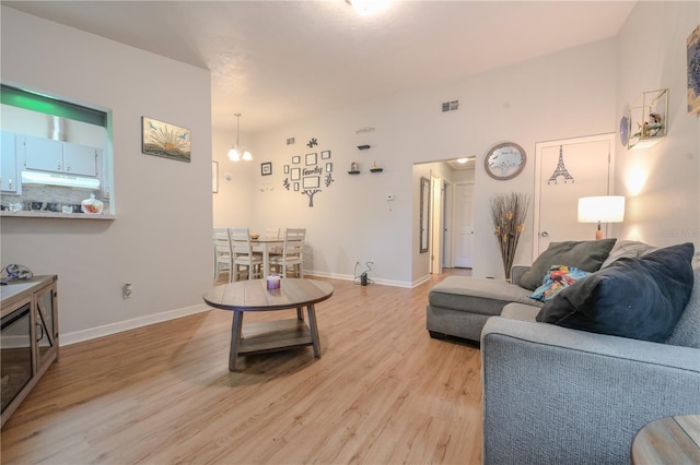 living area featuring light wood finished floors, baseboards, and visible vents