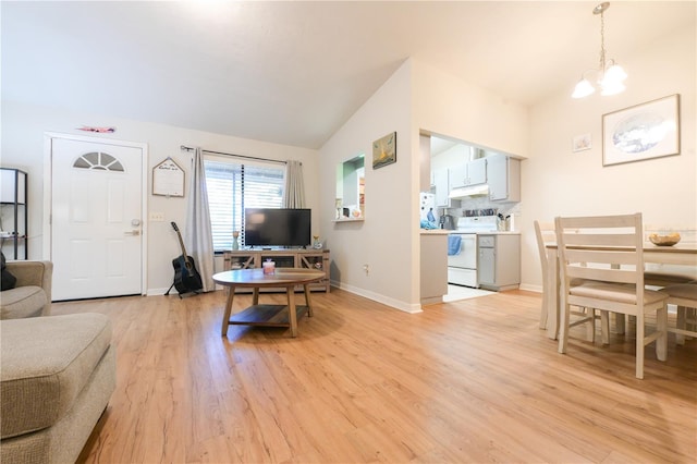 living area featuring lofted ceiling, light wood-type flooring, a chandelier, and baseboards