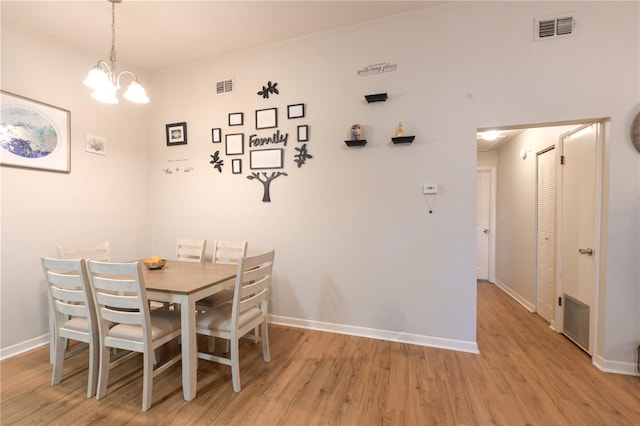 dining area featuring visible vents, a notable chandelier, light wood-style flooring, and baseboards