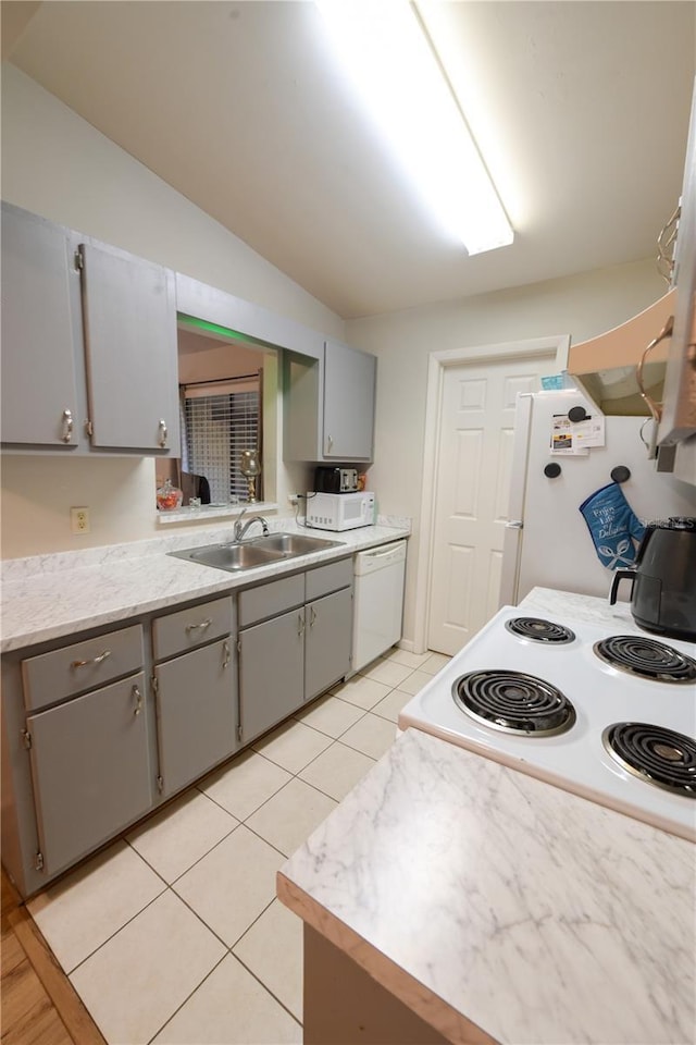 kitchen with white appliances, light countertops, gray cabinets, a sink, and light tile patterned flooring