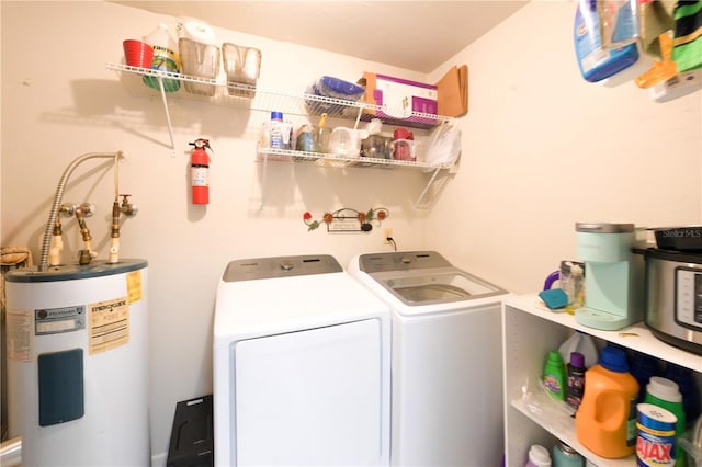 laundry area with laundry area, water heater, and washing machine and clothes dryer