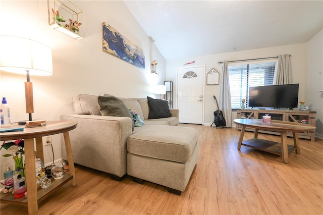 living area with light wood-type flooring and vaulted ceiling