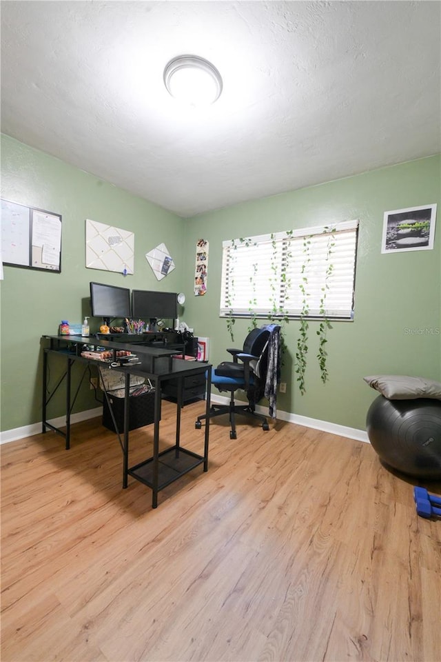 office featuring a textured ceiling, wood finished floors, and baseboards