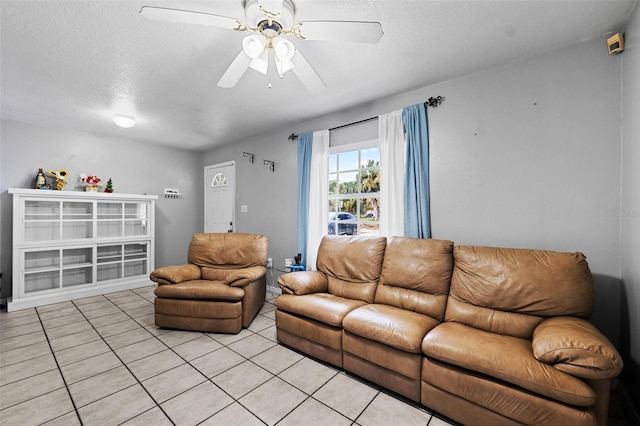 tiled living room with a textured ceiling and ceiling fan