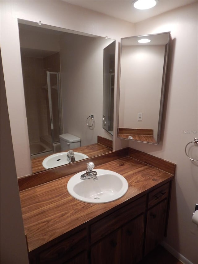 bathroom with vanity, toilet, and an enclosed shower