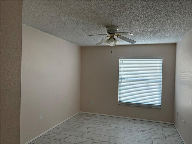 spare room featuring ceiling fan, a textured ceiling, and a wealth of natural light