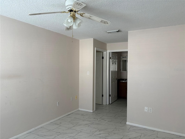 spare room with a textured ceiling and ceiling fan