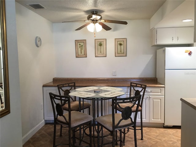 dining room featuring ceiling fan and light parquet flooring