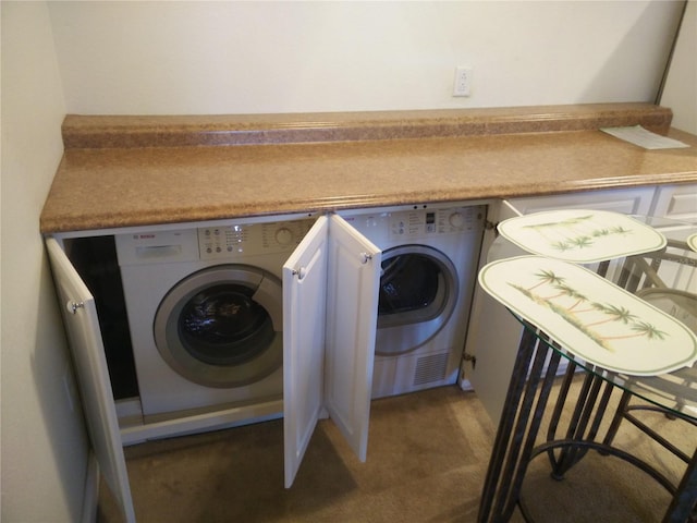 laundry room featuring dark colored carpet and washing machine and clothes dryer