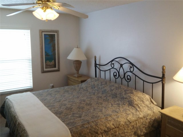 bedroom with ceiling fan and multiple windows