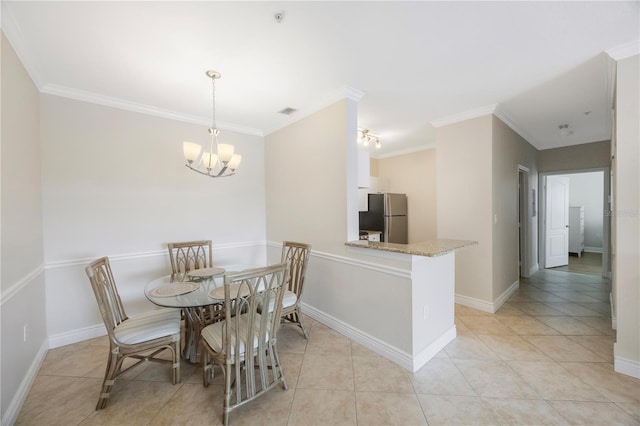 tiled dining space featuring crown molding and a chandelier