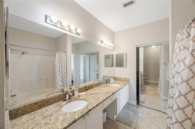 bathroom with toilet, vanity, and tile patterned floors