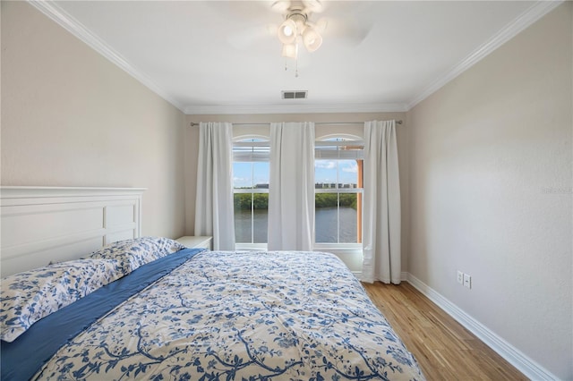 bedroom with ceiling fan, light wood-type flooring, and ornamental molding