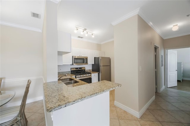 kitchen with kitchen peninsula, light stone countertops, light tile patterned floors, appliances with stainless steel finishes, and white cabinetry