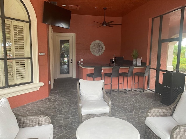 view of patio / terrace featuring ceiling fan and a wet bar