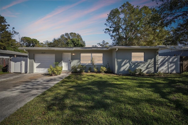 single story home with a lawn and a garage