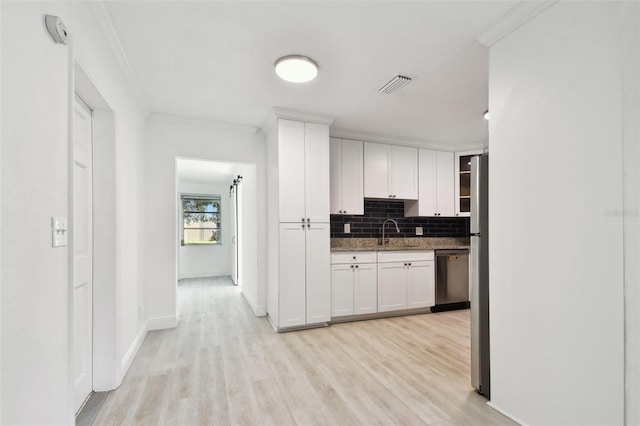 kitchen featuring backsplash, dark stone counters, sink, appliances with stainless steel finishes, and white cabinetry