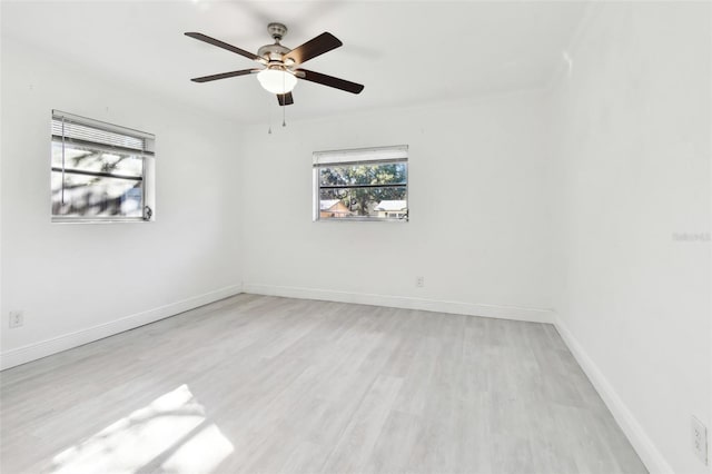 empty room with ceiling fan and light hardwood / wood-style floors