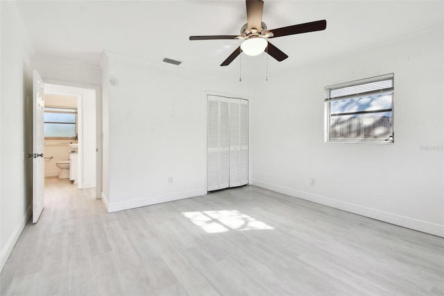 unfurnished bedroom with ceiling fan, a closet, connected bathroom, and light hardwood / wood-style flooring