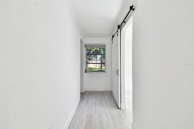 hallway featuring a barn door and light wood-type flooring