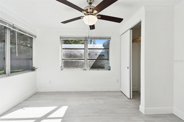 unfurnished room featuring ceiling fan, crown molding, and light hardwood / wood-style flooring