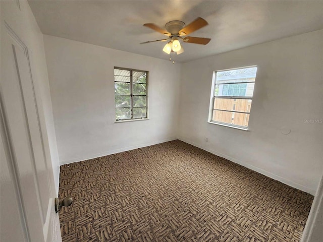 spare room with ceiling fan and a healthy amount of sunlight