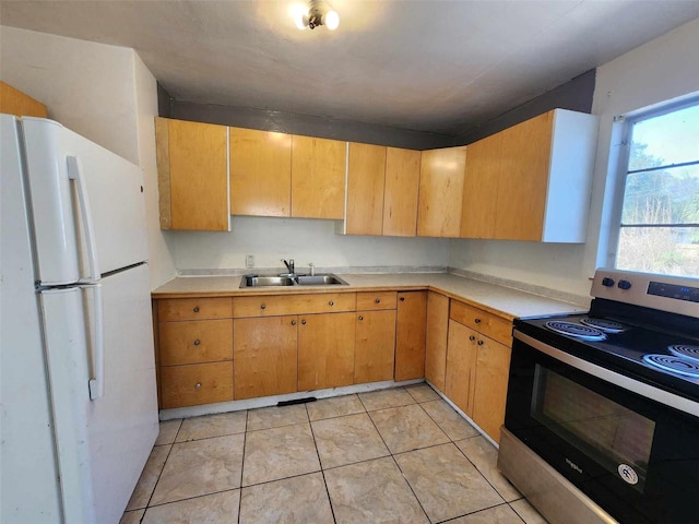 kitchen featuring white refrigerator, stainless steel electric stove, sink, and light tile patterned floors