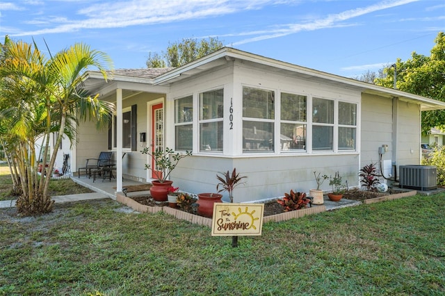 exterior space with a lawn, a porch, and central air condition unit