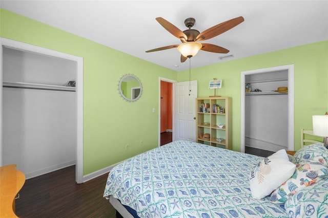 bedroom with ceiling fan, dark hardwood / wood-style flooring, and multiple closets