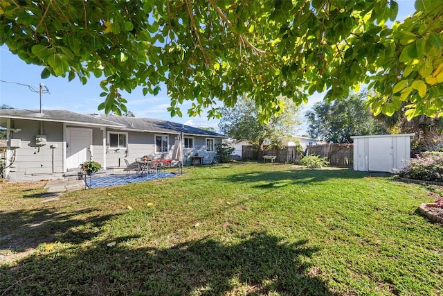 view of yard with a storage unit and a patio