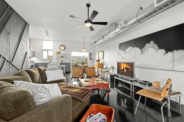 living room with ceiling fan and a fireplace