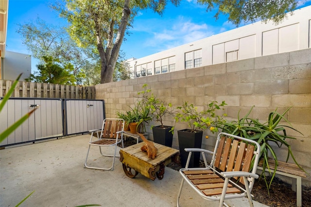 view of patio with fence and a gate