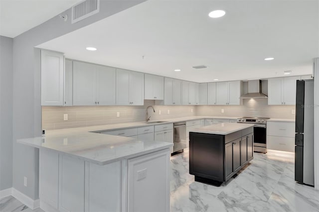 kitchen featuring white cabinetry, sink, wall chimney exhaust hood, stainless steel appliances, and kitchen peninsula