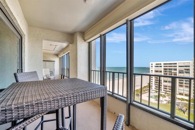 balcony featuring a view of the beach and a water view