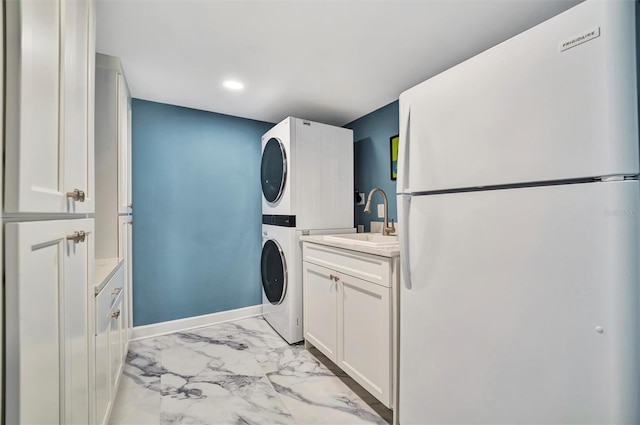 laundry area featuring cabinets, sink, and stacked washer and clothes dryer