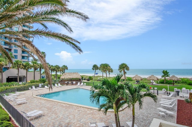 view of swimming pool featuring a patio area and a water view