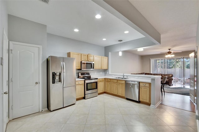 kitchen featuring pendant lighting, stainless steel appliances, kitchen peninsula, and light brown cabinets