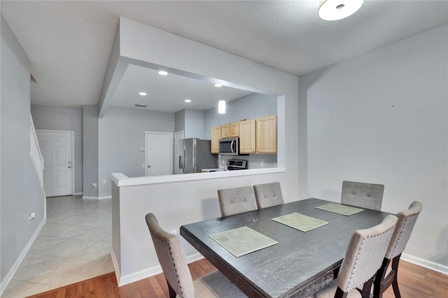 dining area featuring a textured ceiling and light wood-type flooring