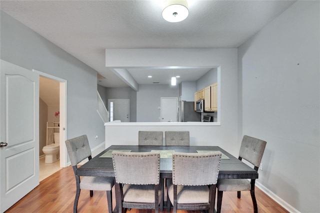 dining room featuring light hardwood / wood-style floors and a textured ceiling