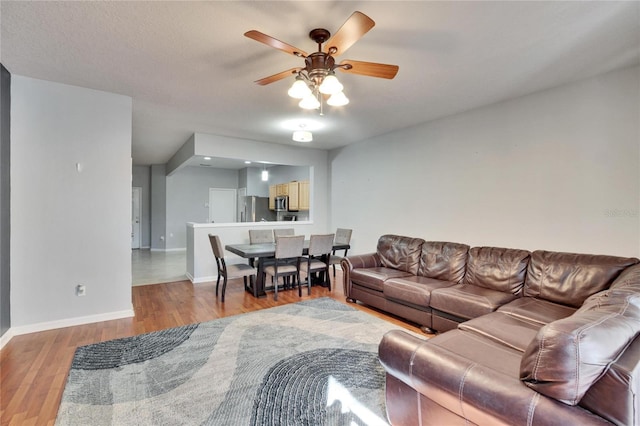 living room featuring light hardwood / wood-style flooring and ceiling fan