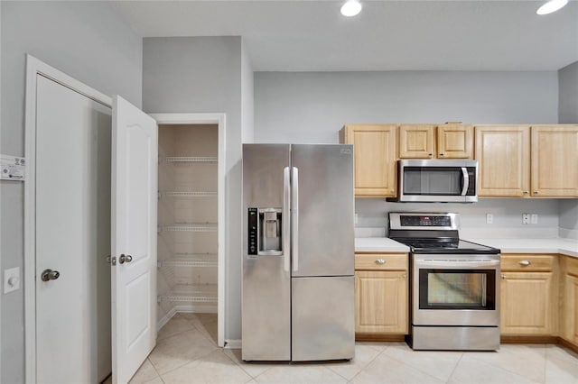 kitchen with light tile patterned floors, light brown cabinets, and appliances with stainless steel finishes