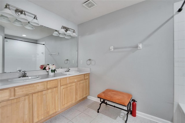 bathroom with tile patterned flooring, vanity, and walk in shower