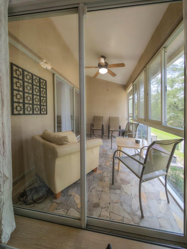 living room with ceiling fan and vaulted ceiling